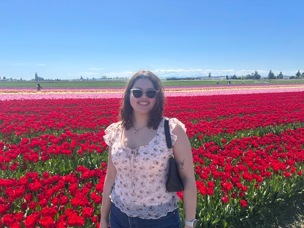 Camilla smiling in a field of red tulips